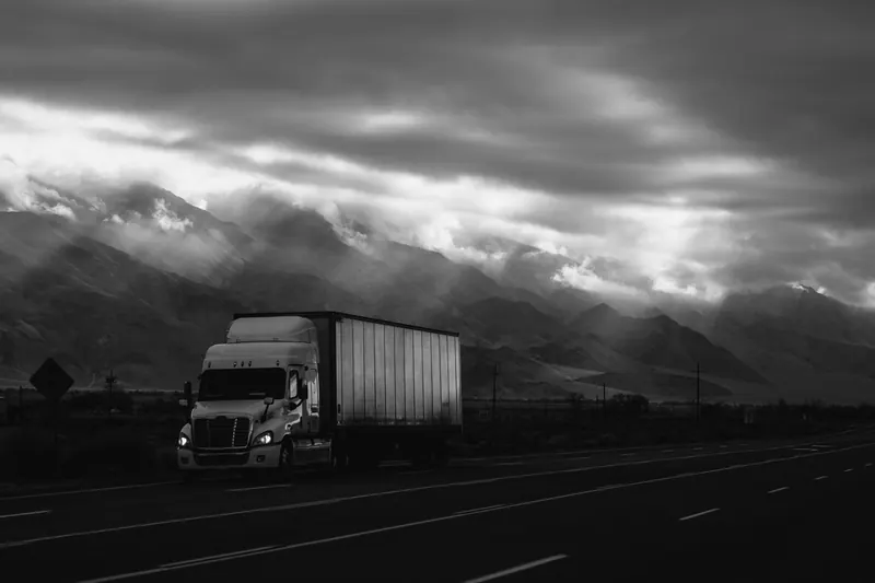 Camion sur route sous un ciel d'orage